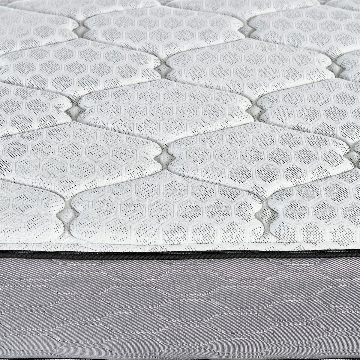 Close-up of a quilted mattress surface with hexagonal pattern.